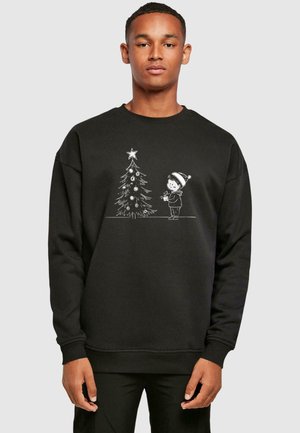 Black sweatshirt featuring a white graphic of a child next to a Christmas tree, with decorative elements and details in a playful style.