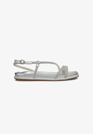 Silver sandals with a flat sole, featuring a strappy design and adjustable ankle strap. The upper has a glittery texture and smooth finish.