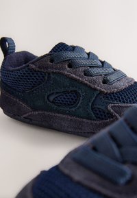 Sneakers blu navy con una combinazione di materiali in mesh e suede, superficie testurizzata, cuciture a contrasto e design con lacci.