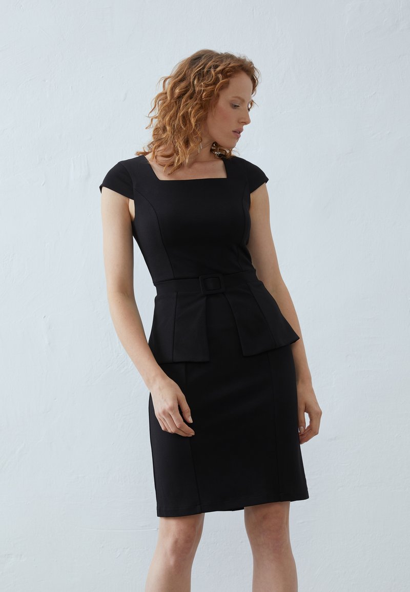 Robe noire ajustée avec un décolleté carré, des manches courtes en cap, une taille peplum et une ceinture accentuée. Tissu lisse avec une texture unie.
