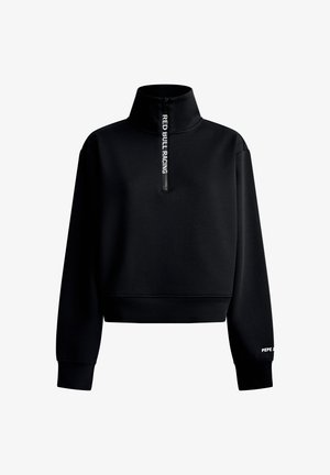 Melnā, garām piedurknēm džemperis ar augstu apkakli un rāvējslēdzēju, uz kura ir uzraksts "RED BULL RACING" un mazs balts uzraksts "PEPE" kreisajā aprocē.