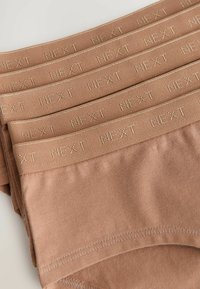 Confezione di quattro slip in cotone color marrone chiaro con logo ricamato "NEXT" sull'elastico, caratterizzati da una texture liscia e una banda elastica.