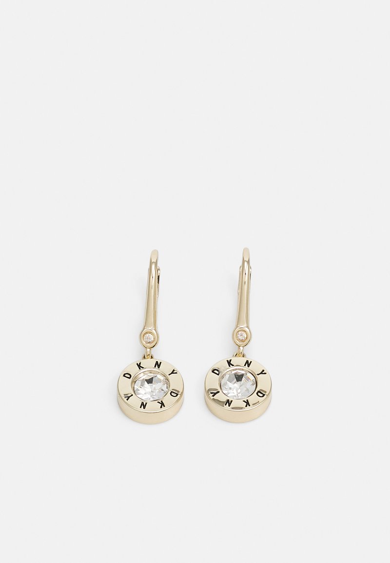 Boucles d'oreilles dorées avec un charme circulaire au centre orné d'une pierre précieuse transparente et "DKNY" gravé tout autour. Fermoir à levier simple.
