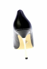 Scarpa nera in pelle con tacco alto a stiletto sottile di colore oro metallizzato, mostrata da dietro su sfondo bianco.