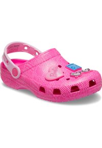 Ροζ παπούτσι στυλ κροκοδείλου με καρδιά και αξεσουάρ, διαθέτοντας αεραγωγούς και ιμάντα πίσω για ασφαλή εφαρμογή. Υφασμένο από υλικό καουτσούκ με υφή.