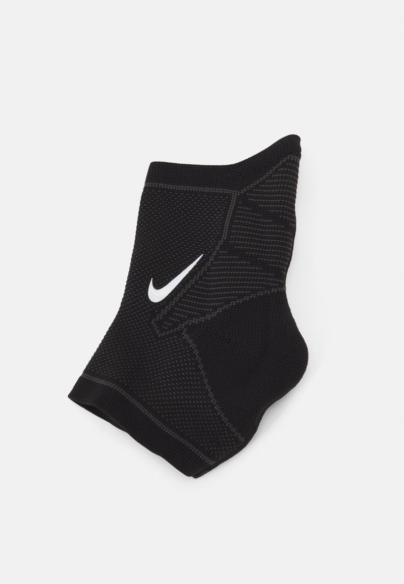 Fekete sportzokni, textúrált felülettel, kontrasztos fehér Nike logóval. Teljesítményre és támogatásra tervezve.