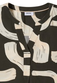 Halenka s límečkem z tmavě zelené látky s béžovým abstraktním vzorem štětcových tahů, s knoflíkovým rozparkem na výstřihu a jemnými šicími detaily.