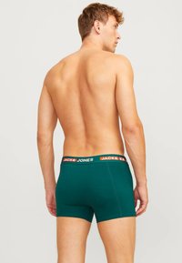 Groene boxershorts met een contrasterende zwart-oranje tailleband met het label "JACK & JONES"; soepele, rekbare stof, nauwsluitend ontwerp.