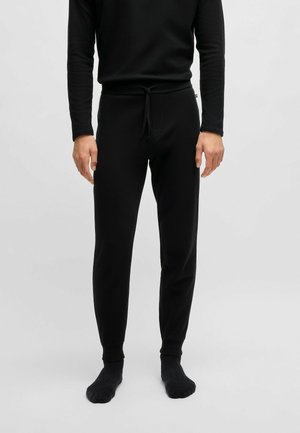 Zwarte lange mouw top en bijpassende tapered jogger broek. De stof heeft een gestructureerd patroon. De broek heeft een drawstring taille en boorden.