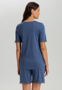 Conjunto de top de algodón azul y pantalones cortos, con bordes festoneados en las mangas y en el dobladillo, ajuste relajado, textura suave y un sencillo escote redondo.