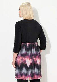 Abito in gradiente di nero e rosa con maniche 3/4, caratterizzato da una vita a peplo e un motivo astratto in tonalità di viola, rosa e nero.