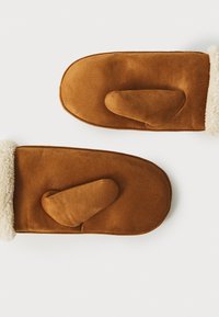 Brune suedetætsjer med en blød creme faux fur-manchet, rund form og et karakteristisk tommelfingerlomme-design. Glat tekstur overalt.