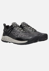 Czarno-szare buty outdoor z siateczkową cholewką, wyściełanym kołnierzem, trwałym gumowym noskiem i teksturowaną gumową podeszwą zapewniającą przyczepność. Zawierają elementy odblaskowe.