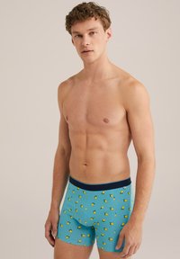 Svijetloplave bokserice s uzorcima žutih limuna, mekana tkanina, elastična pasica s tamnoplavim naglaskom, uski kroj.