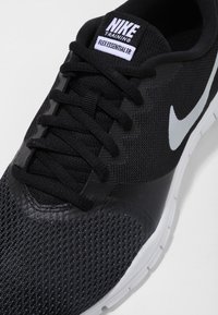 Scarpa da allenamento Nike Flex Essential TR nera. Presenta una tomaia testurizzata, dettagli neri lisci e un logo Swoosh bianco di Nike.