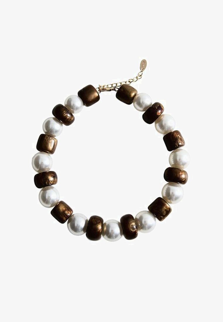 Bracelet en perles marron et blanches avec des perles rondes et carrées, présentant des finitions nacrées brillantes et métalliques texturées. Accessoirisé d'une chaîne dorée.