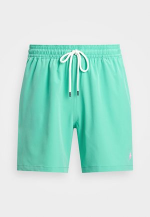 Mintgrønne badshorts med elastisk talje, hvit snor og en liten rosa logo på venstre frontside. Glatt tekstur.