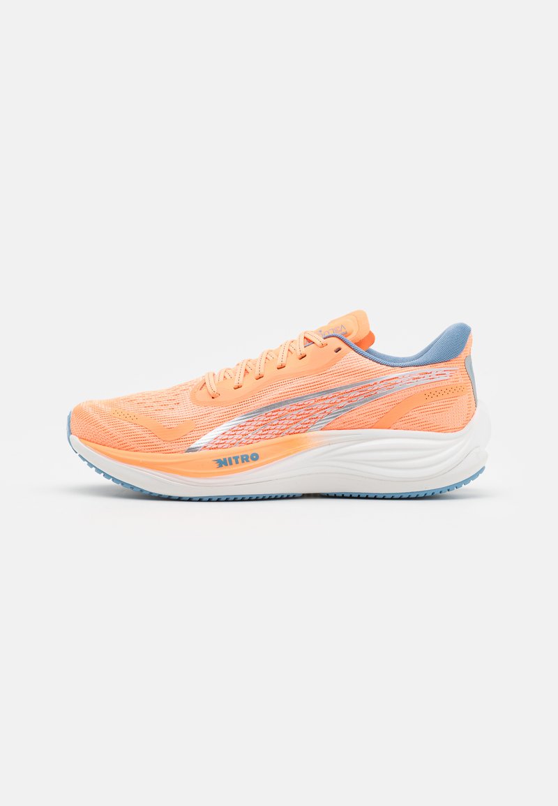 Zapatilla de carrera naranja con parte superior de malla, acentos azules y franjas reflectantes. Presenta una suela blanca acolchada y una suela texturizada para mayor agarre.