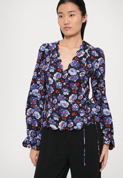 Blusa nera con motivo floreale blu e rosso, scollatura a taglio scallop, maniche lunghe con polsini arricciati e dettaglio con fiocco sul lato.