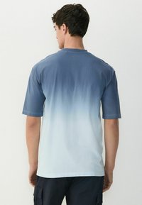Kortærmet T-shirt med et ombre-design fra mørkeblå til lyseblå, lavet af blødt bomuld med rund halsudskæring og ensfarvet ryg.