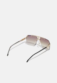 Ochelari de soare rectangulari cu o ramă din metal aurit, lentile cu gradient care trec de la deschis la închis și brațe subțiri negre.