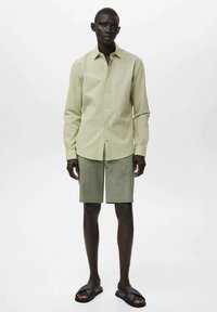 Hellgrühe, strukturierte Knopfleiste-Hemd, olivgrüne Shorts und schwarze Sandalen. Einfaches Design, kurze Ärmel, lässige Passform.