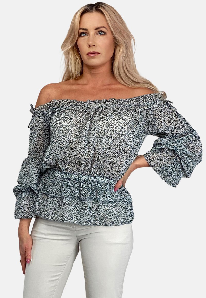 Bluzka z odkrytymi ramionami w jasnoniebieskim kolorze z kwiatowym wzorem, z falbankami na rękawach i elastycznym pasem, w zestawie z białymi spodniami.