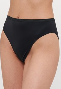 High-waisted black bikini bottom made from smooth fabric, featuring a subtle Calvin Klein logo on the waistband and a sleek, minimalist design.