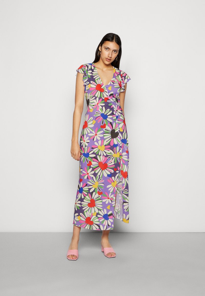 Vestido floral envolvente com base roxa, mangas curtas com babados, padrões de corações e margaridas em vermelho, rosa, azul e verde, com uma fenda lateral.