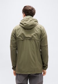 Φούτερ μπουφάν με κουκούλα σε ελιάς πράσινο χρώμα, με λεία υφή, που διαθέτει πίσω πάνελ yoke και ελαστικά μανίκια. Σχεδιασμένο για άνετη εφαρμογή.