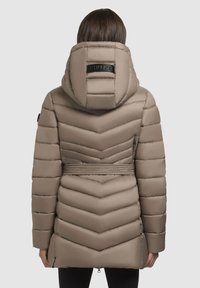 Beige pufferjack met een chevronpatroon, voorzien van een капюшон, verstelbare riem in de taille en zijzakken. Gladde, glanzende afwerking.