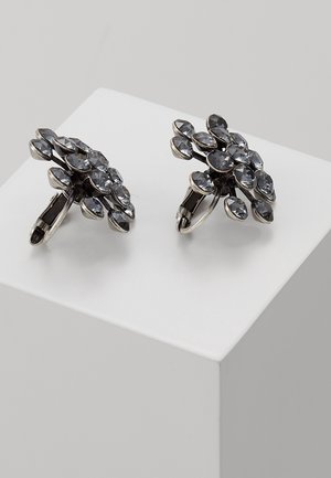 Par sølvfarvede clip-on øreringe med flere runde, facetslebne mørkegrå ædelstene arrangeret i et blomsterklynge-design.