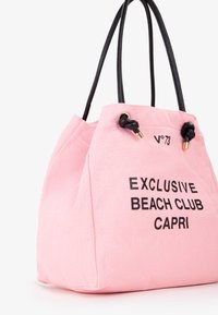 Roze canvas emmertas met zwarte leren handvatten, voorzien van de tekst "EXCLUSIVE BEACH CLUB CAPRI" gedrukt in vette zwarte letters.