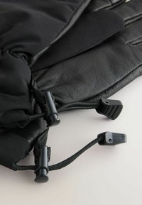 Guanti neri realizzati in pelle e tessuto, con palmo in pelle testurizzata e corde elastiche regolabili con fermagli in plastica per la personalizzazione.