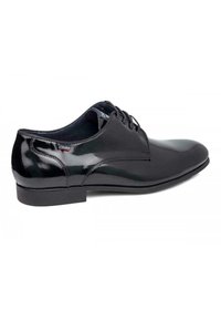 Scarpa da uomo in pelle verniciata nera con sistema di allacciatura chiusa, punta arrotondata e suola piatta. Presenta una texture liscia e raffinata con minimalismi decorativi.