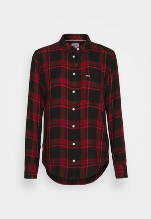 Camisa de manga larga con botones, con patrón de cuadros rojos y negros y bolsillo en el pecho sobre fondo blanco.