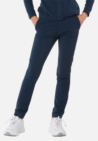 Fleece joggers i mørk navy med en slim fit, der har sidelommer og ribbede cuffs. Parret med hvide sportsko.