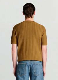 Brown ribbed knit short-sleeve top with a round neckline, paired with light blue denim jeans featuring back pockets.