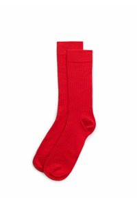 Calcetines de algodón rojos con textura acanalada, diseño hasta la rodilla y áreas reforzadas en los dedos y el talón para mayor durabilidad.