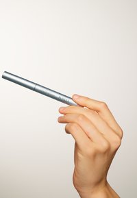 Ombre à paupières Cool Colour de KIKO dans un tube en métal argenté, arborant une forme cylindrique et un design minimaliste, tenu par une main.