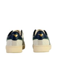 Et par hvide sneakers med navy blå hælkapsler og grønne striber, set fra bagsiden på en hvid baggrund.