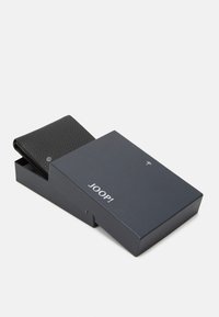 Črn usnjeni denarnica z teksturirano površino, razstavljena v temno modri darilni škatli z logotipom. Škatla ima preprost, sodoben dizajn.