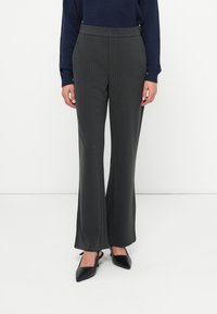 Dark gray pinstripe trousers with a fitted waist, flared legs, and smooth material, paired with pointed black heels.