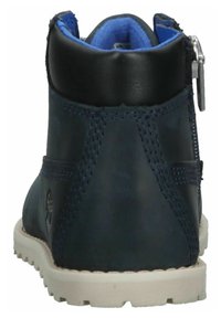 Botas de tobillo de cuero azul marino con un cuello acolchado, suela de goma blanca y cremallera lateral para un fácil uso. Detalles de costura a lo largo de las costuras.