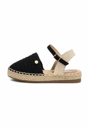 Sandali espadrillas con tomaia nera intrecciata e cinturino alla caviglia beige. Presentano una piattaforma in juta intrecciata e una suola piatta in gomma.