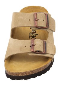 Sandal de ante beige con dos hebillas ajustables, plantilla moldeada y suela texturizada marrón. En el interior presenta un logo de la marca y un forro suave.