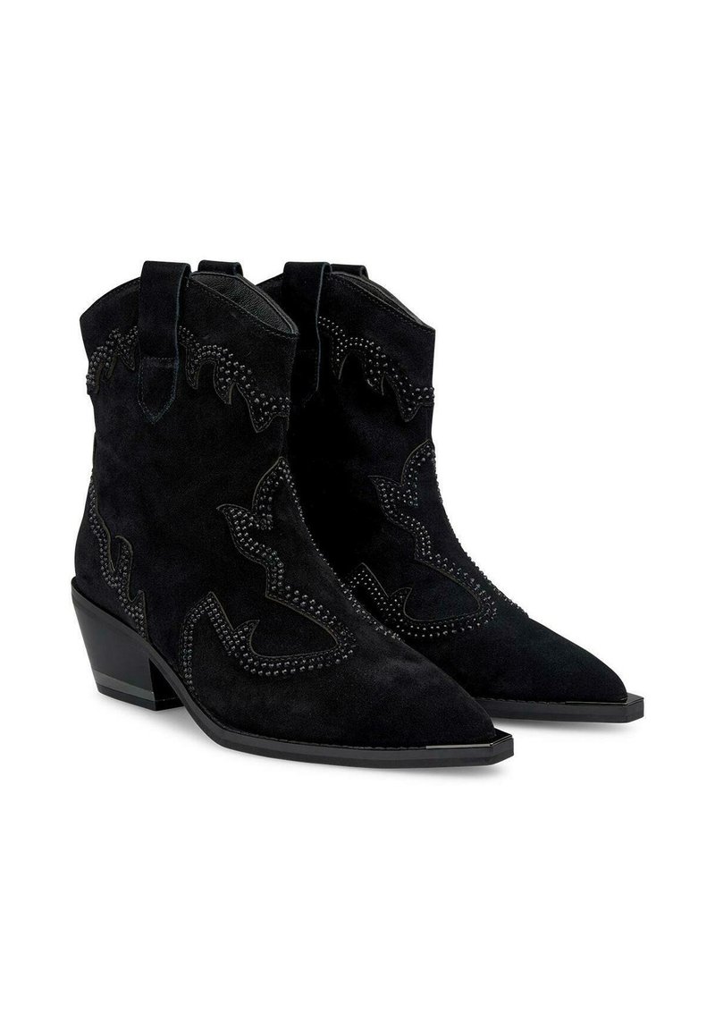 Stivaletti in suede neri alla caviglia con punte appuntite, cuciture decorative e dettagli borchiati. Presentano un tacco basso e linguette per un facile indossamento.