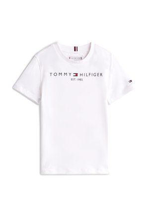 T-shirt en coton blanc à manches courtes, arborant "TOMMY HILFIGER EST. 1985" imprimé avec des détails de logo en noir et rouge sur la manche.