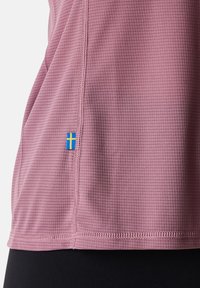 Maglietta leggera a maniche corte di colore rosa con un motivo a griglia testurizzato. Presenta un dettaglio di bandiera blu e gialla cucito sulla cucitura laterale.
