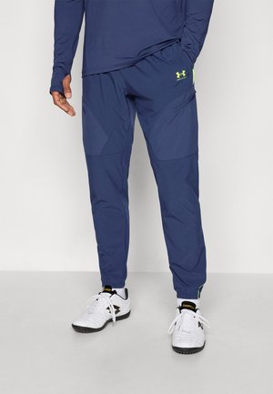 Marineblauwe sportbroek met een tapse snit, voorzien van een gestructureerde afwerking, elastische boorden en een Under Armour-logo in neon groen.